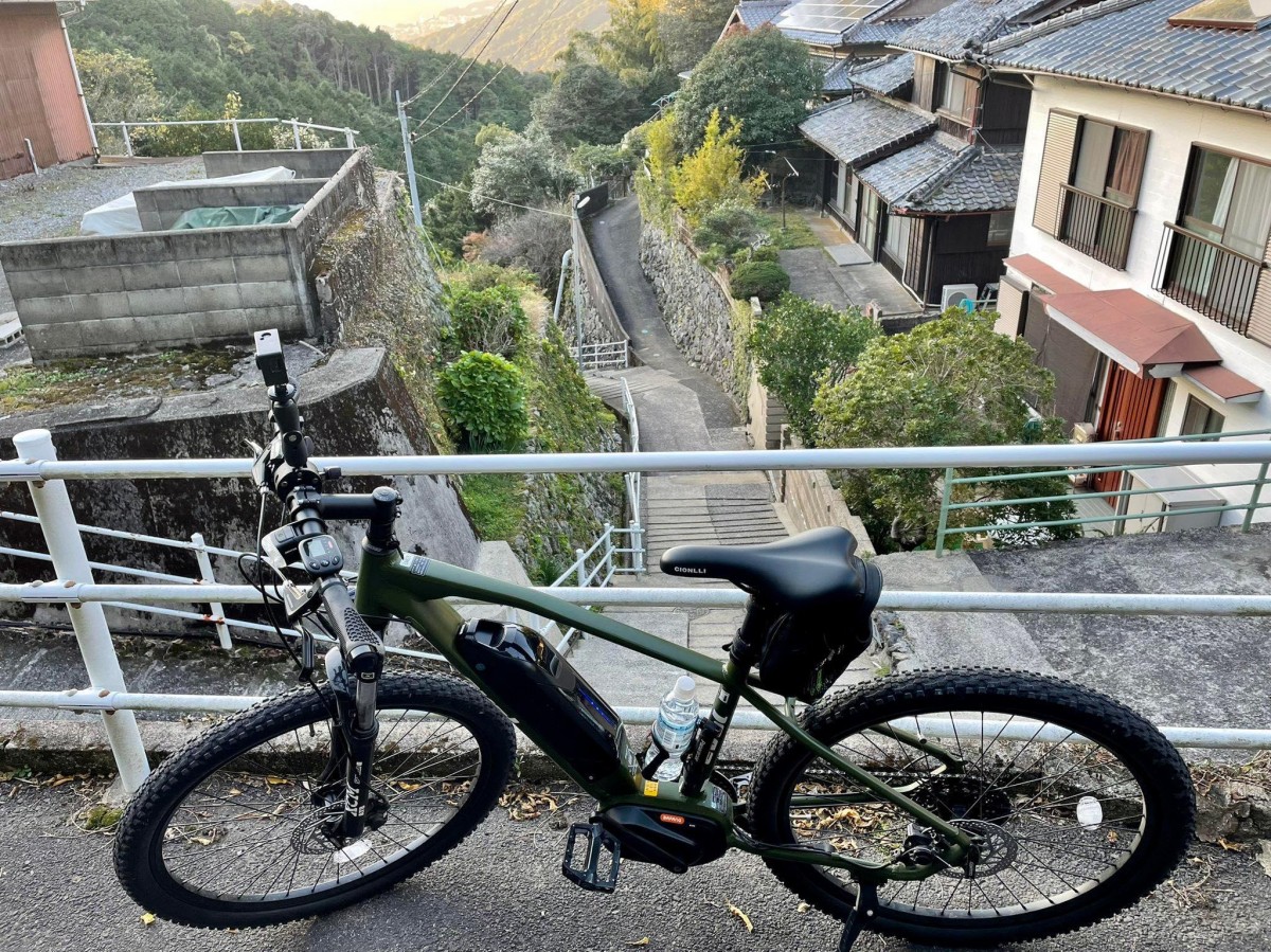 長崎の坂を自転車で登る植松さん