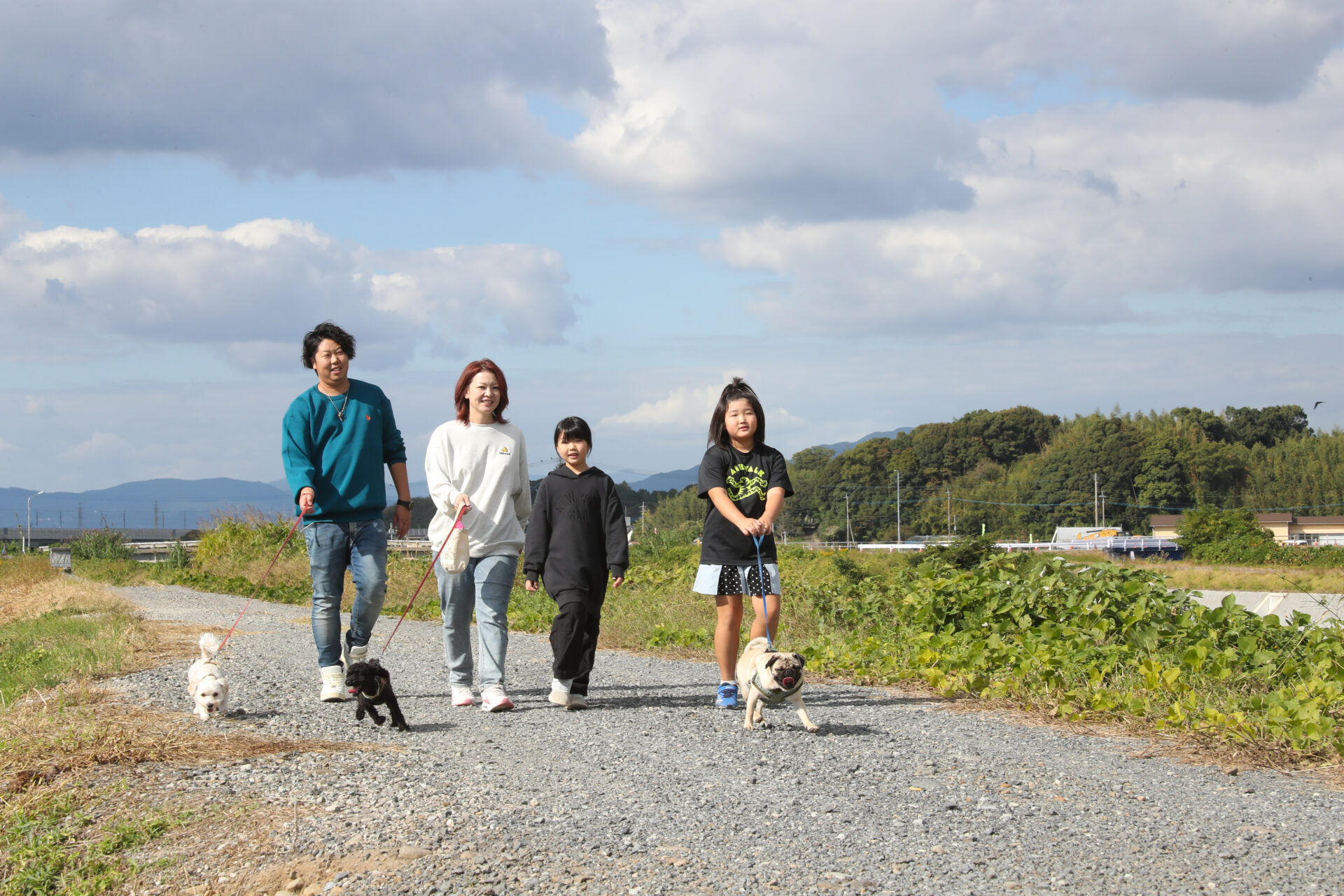自宅近くの土手を散歩する山本さん家族