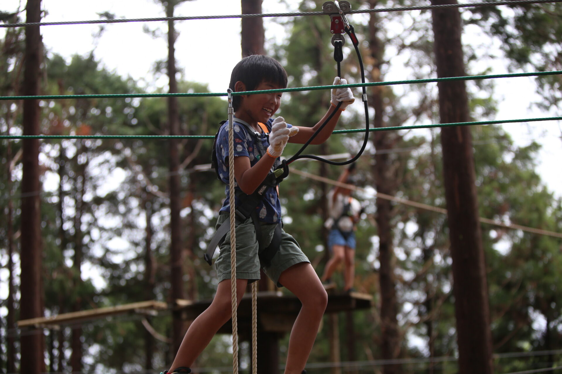 男の子がジップラインで遊んでいる写真